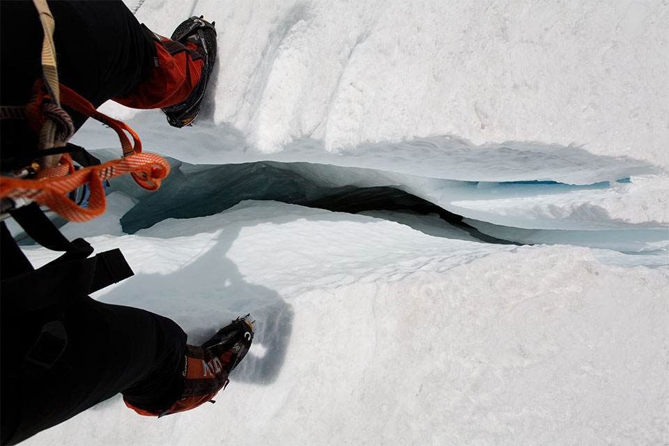 Jamie steps across a small but deep crevasse